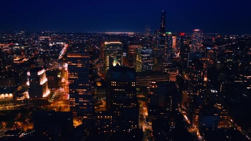 Brightly illuminated streets of New York, USA at night. Dazzling cityscape from aerial perspective.