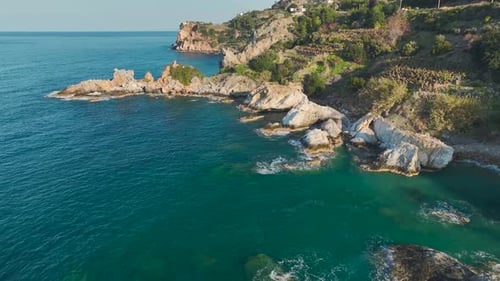 Aerial Video of Rugged Stone Shore With Waves Crashing in Turquoise Mediterranean Sea Water