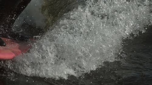 Skimboarding on Dark Water Creates Splashes
