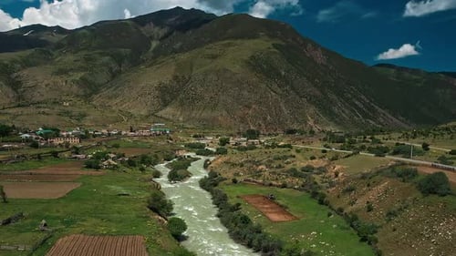 Fluss, der durch ein üppiges grünes Tal fließt, umgeben von Bergen und einem üppigen grünen Tal