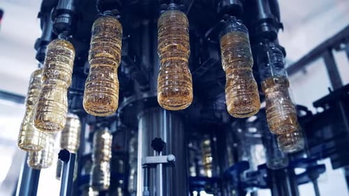 Producción de aceite de cocina. Botellas de plástico llenas de aceite de oliva en el interior de la moderna fábrica.