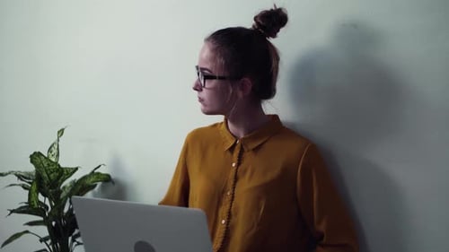 Woman with Glasses Typing on Laptop at Home