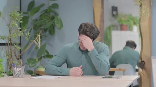 Stressed Man with Headache at His Desk