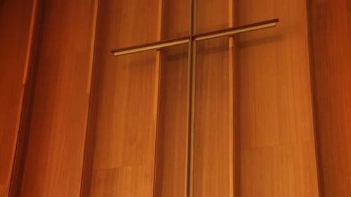 A long metal cross inside a historic church sanctuary.