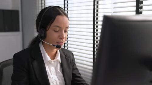 Competent Female Operator Working on Computer and While Talking with Clients