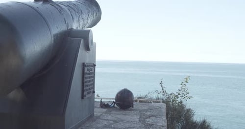 Old historic gun on top of mountain with wide ocean in background.Protection in Medieval time.