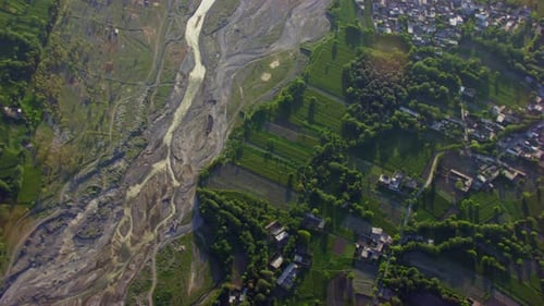 A river and a valley Aerial view, Green trees, grass and forest with houses, Camera is top at the ri