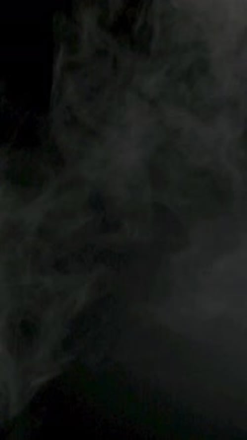 Vertikales Zeitlupenvideo von weißem Rauch, Nebel, Dunst und Dampf auf schwarzem Hintergrund.