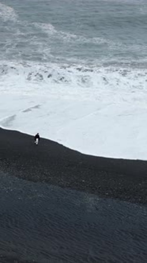 Experience the Stunning Beauty of Aerial Views of a Dramatic Black Sand Beach in Iceland with Waves