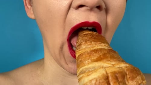 Close-up female mouth colored lips eats pastry food isolated background