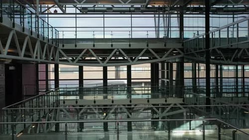 Modern office atrium balconies pan up to skylight architecture