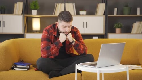 Man Working on Laptop at Home on Couch