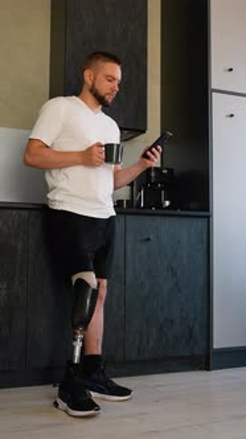 A Man Amputee with Prosthetic Leg Enjoying Coffee And Use Phone After Rehabilitation
