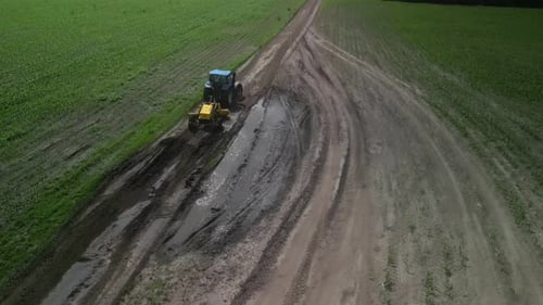 Grader arbeitet mit Traktor und ebnet die Feldstraße