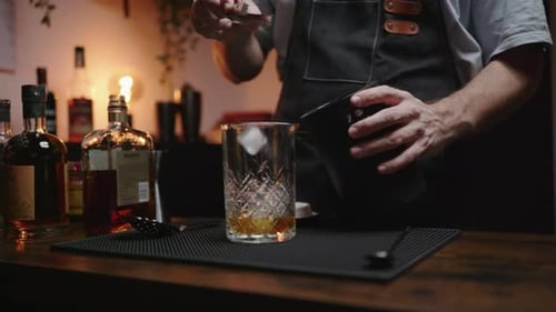 Bartender Making Cocktail on Bar Top at Night