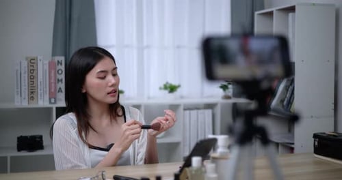 Hermosa bloguera asiática está mostrando cómo maquillar y usar cosméticos