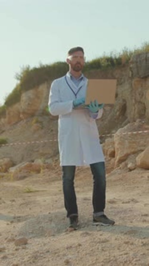 Scientist Holding a Box in a Rocky Area