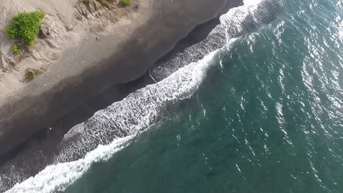 Aerial View of Waves Crashing on Black Sand Beach