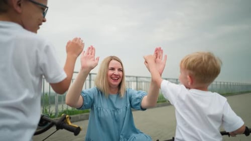 Mother and Children Sharing a Fun High Five Moment Outdoors