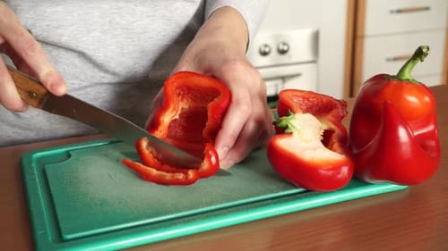 Slicing Red Bell Pepper on Green Board