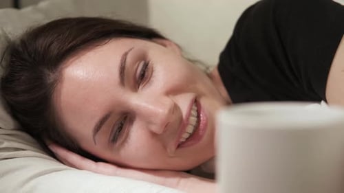 Woman Lies on the Bed a Coffee is Brought to Her She Wakes Up and Takes a Sip