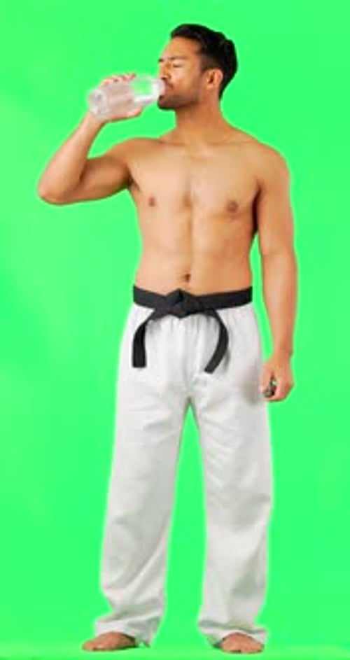 Karate, green screen or tired man drinking water after fitness exercise