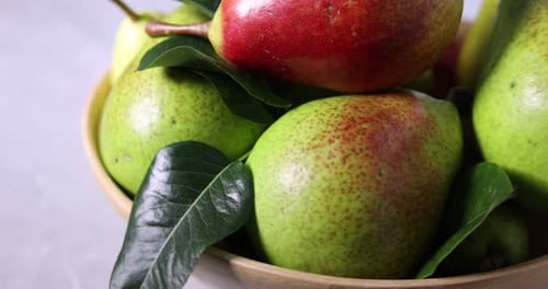 Fresh ripe pears and green leaves on table, closeup