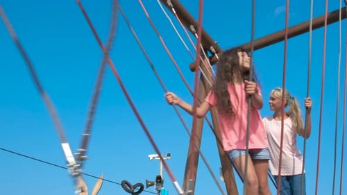 Children Playfully Navigating a Jungle Gym on Bright Day