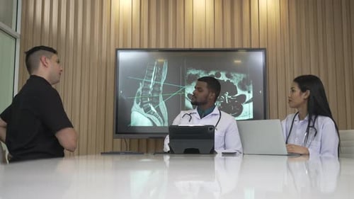 Patient Consults Doctors Viewing X-Ray in Office