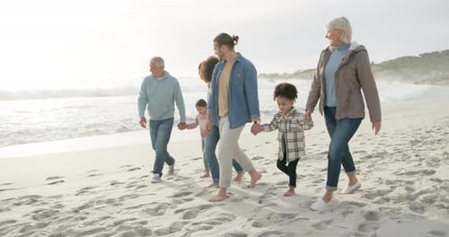 Happy, holding hands and interracial family on the beach for walking, bonding and holiday