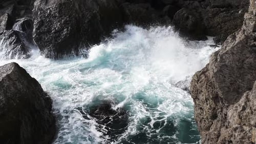 Sea waves break into white foam on the coastal rocks. Power of nature. Water ele