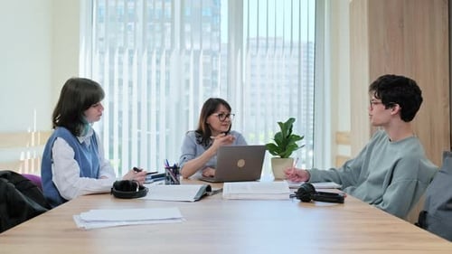 College Students with Teacher Sitting at Desk in Classroom Studying Languages Sciences