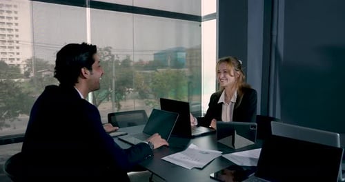 Smiling business colleagues shaking hands after agreement during team meeting in office. Successful