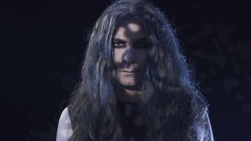Man with Long Hair and Dark Makeup Staring