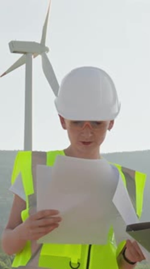 Engineers Review Wind Turbine Operations Onsite Ensuring Safety with Highvisibility Vests and