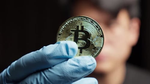 Gloved Hand Holding Bitcoin Cryptocurrency Close Up