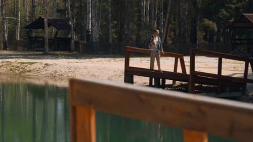 Beautiful lake with pier and man holding dog in hand