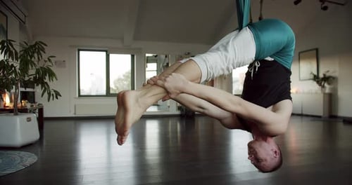 Adult Male Doing Aerial Yoga in Studio