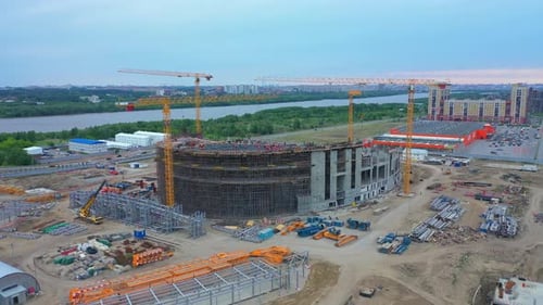 Edificio de centros deportivos y grúas en funcionamiento en una gran ciudad
