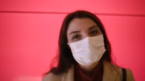 Woman Wearing Surgical Mask on Pink Background