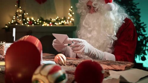 Santa Claus Reading Christmas Letter at Table