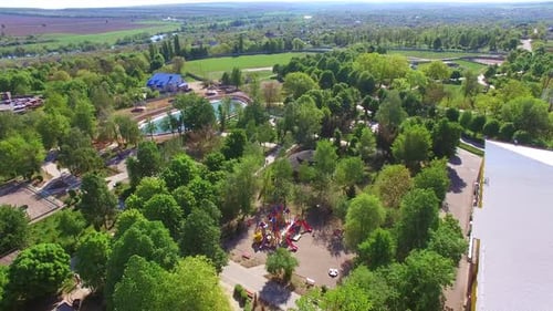 Beautiful green city park with artificial pond in the middle. Acres of greenery and walking paths