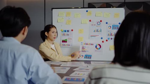 Business Meeting with Charts and Whiteboard in Office