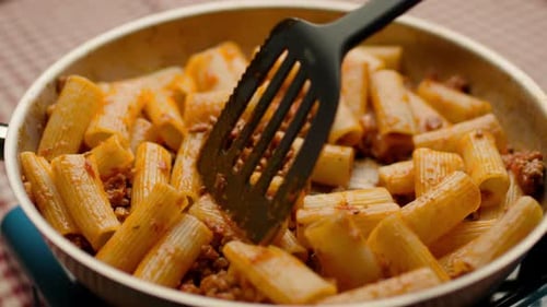 Pasta and Meat Sauce Being Stirred in Skillet