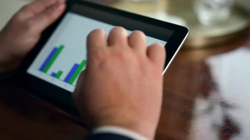 Die
Hände eines Unternehmers verwenden einen Tablet-Check mit Finanzgrafiken auf der Nahaufnahme einer Geschäftsreise. Unerkannt