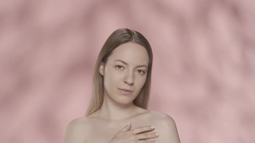 A Young Woman Enjoys Her Perfect Skin Gently Touching Her Shoulders with Her Hand Portrait of a