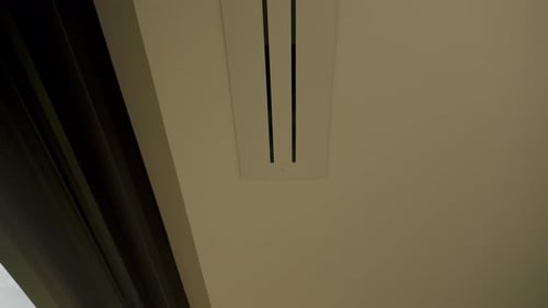 Slow tilting revealing shot of aircon vents at the window of a luxury villa
