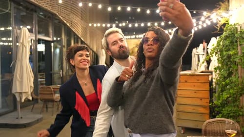 Friends Take Smiling Selfies Outdoors at Night