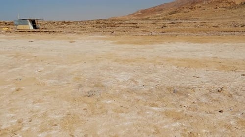 Pan across low lying salt flat evaporation zone on the toe slope of the Dead Sea