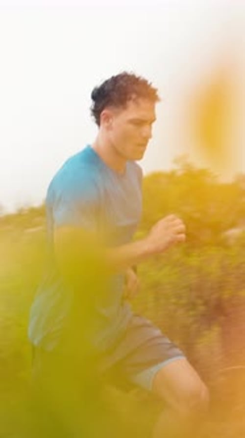 Athletic Man Runs Through Tall Grass Trail Workout